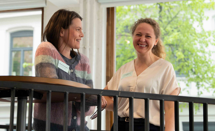 Sofia A. Strand fra Forskningsrådet i samtale med Wenche Gerhardsen fra Oslo Cancer Cluster under et arrangement i regi av Cancer Mission Hub Norge i mai 2026. Foto: Jorunn Valle Nillsen.